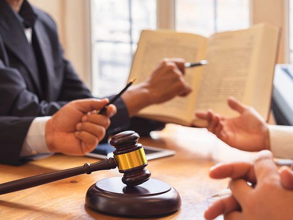 A group of people sitting around a table with papers and a gavel.