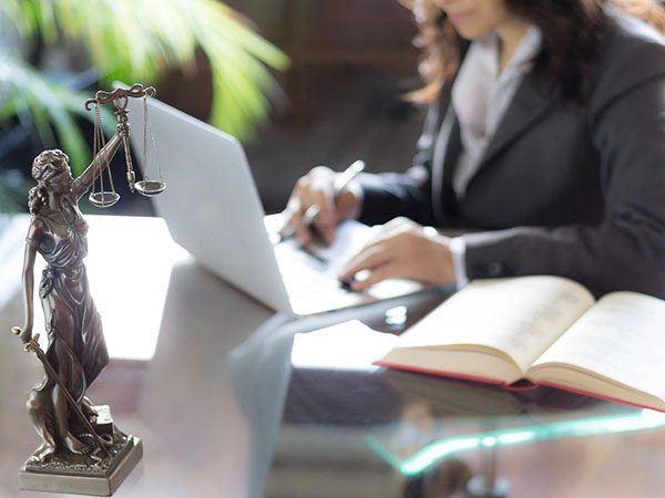 A woman sitting at a table with a laptop.