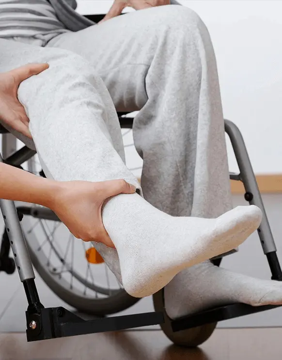 A person in a wheelchair with one foot on the ground.